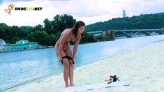 Playful young nudist with nice body is having fun the beach