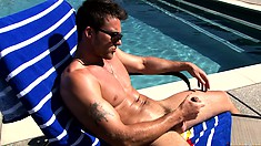 Studly gay dude sunbathing by the pool grabs his meat to jerk